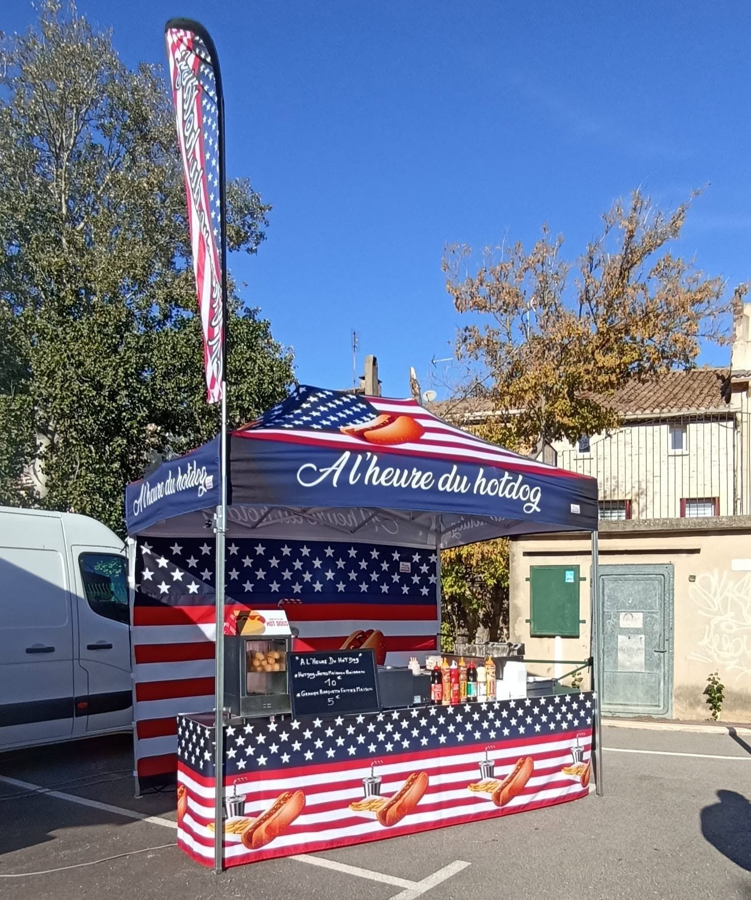 Le stand A l’heure du hotdog monté sur une place, barnum bleu blanc rouge